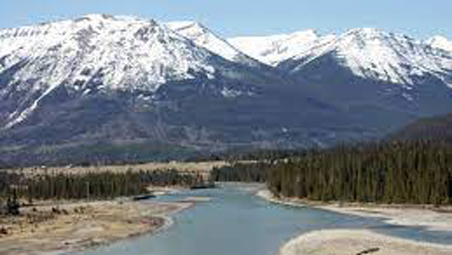 Blue river winding through forest in mountain valley