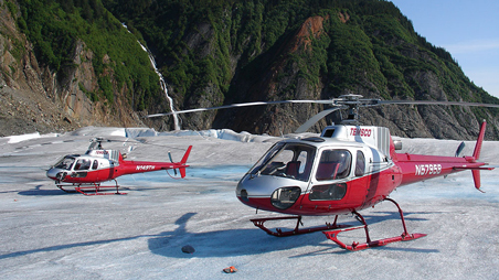 Two Temsco helicopters sitting on a remote airfield