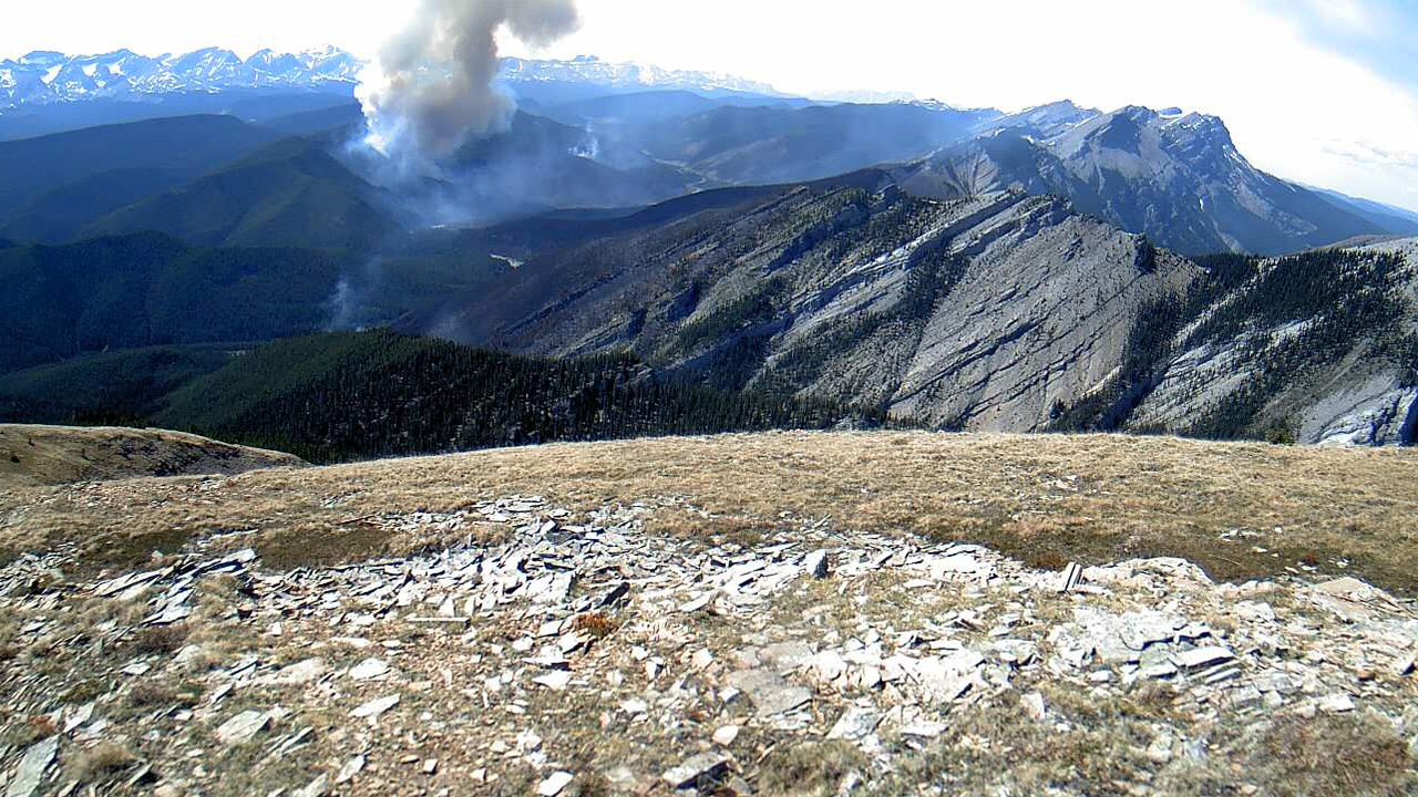 Smoke rising from wildfire in remote mountain range, Alberta